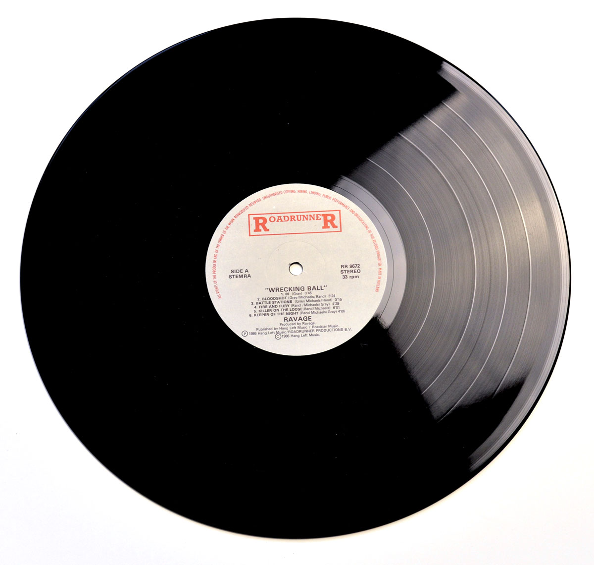 Side A label of the 1986 RAVAGE - Wrecking Ball LP on Roadrunner Records featuring tracklist and credits printed on a white center label